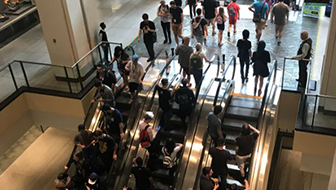 Large groups of people going up and down escalators at a convention centre